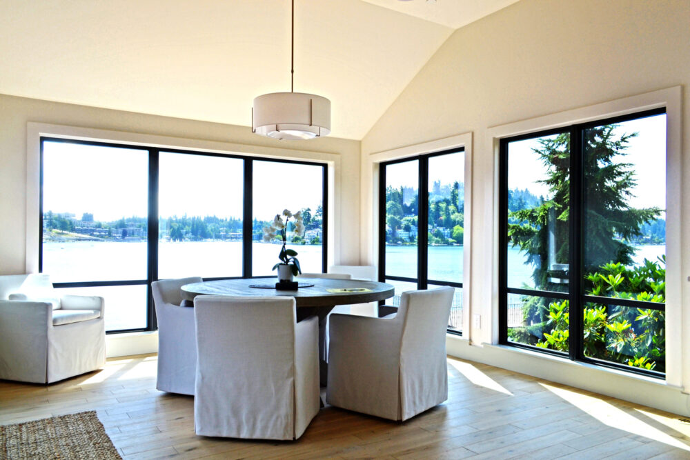 The dining room with large windows looking out to the water and landscape beyond.