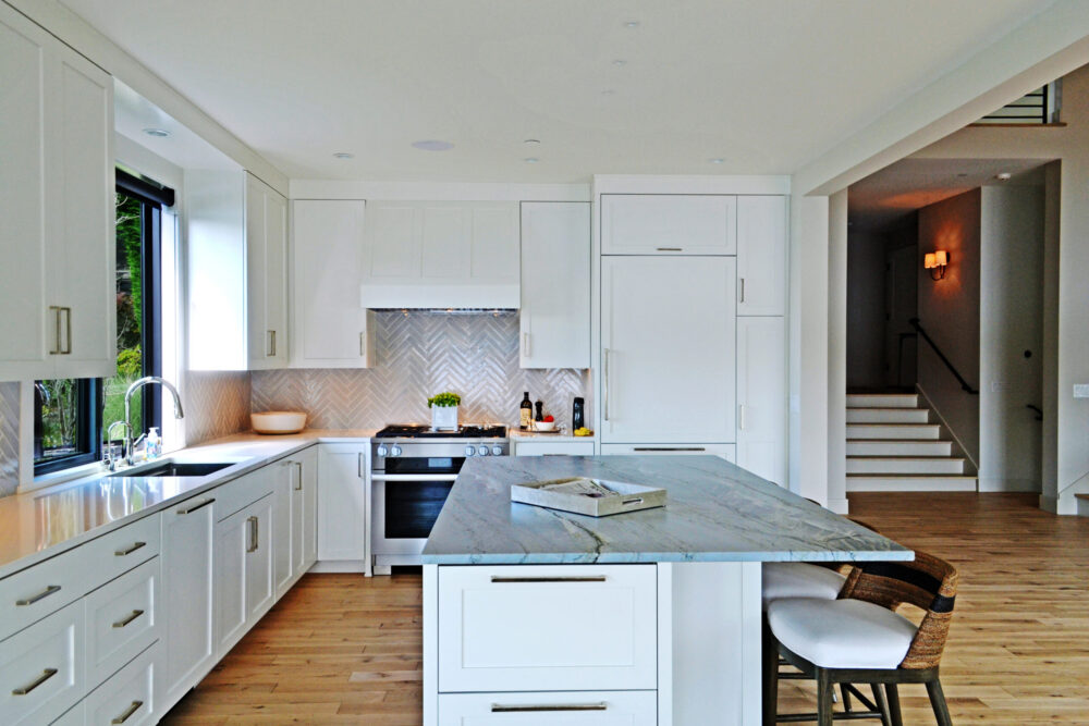 The kitchen with white cabinetry and a figured countertop at the kitchen island.